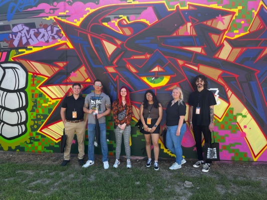 Students standing in front of mural.