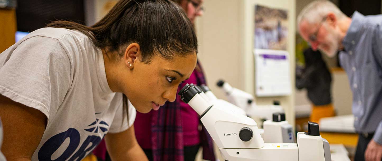 student looking in microscope
