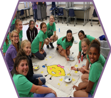 A group of girls work together to design and paint their dorm banner, which represents the laboratory lemons.