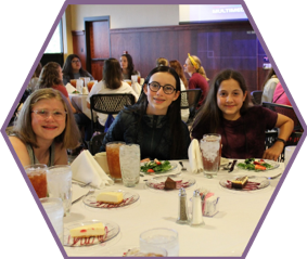Three campers learn how the rules of dinner etiquette during the Professional Etiquette workshop.