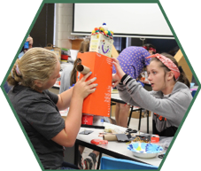 Two campers work together to build a robot from scratch utilizing recycled materials.