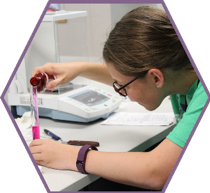 A camper creates anti-itch gel by pouring a pink solution into a graduated cylinder.