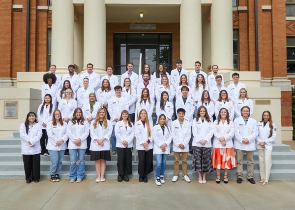 Pharmacy class photo outside.